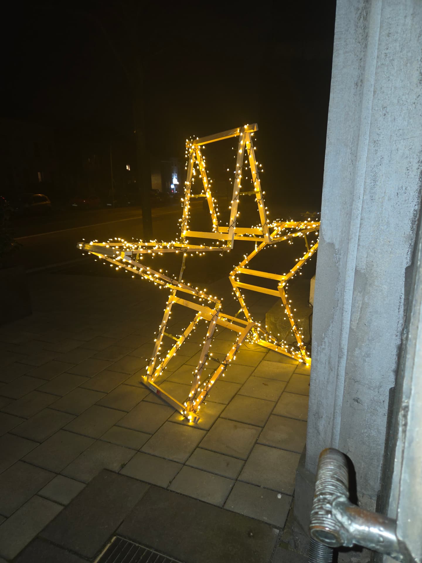 Beleuchteter Holzstern vor dem Eingang